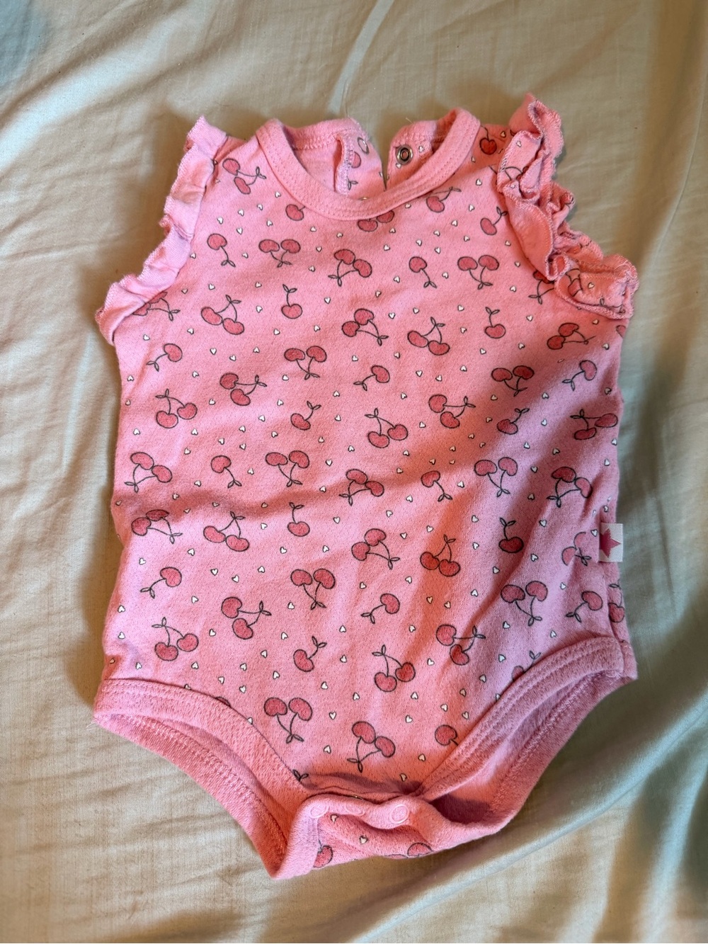 Millie & Miles pink sleeveless ruffled baby bodysuit cherry heart print pattern